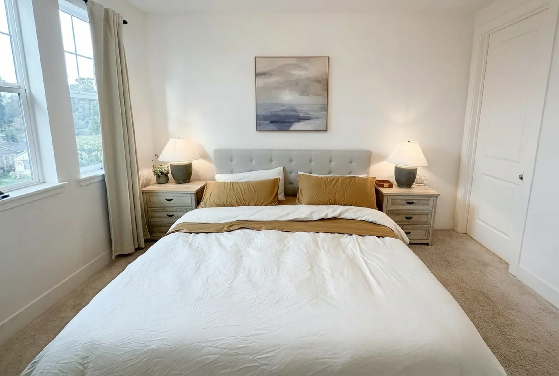The primary bedroom, dressed simply in white and gold.