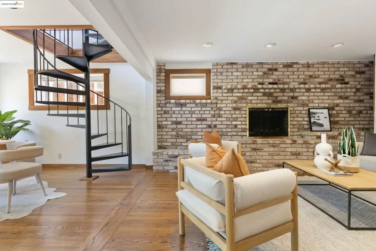 The lower-level living room, brick fireplace and all.